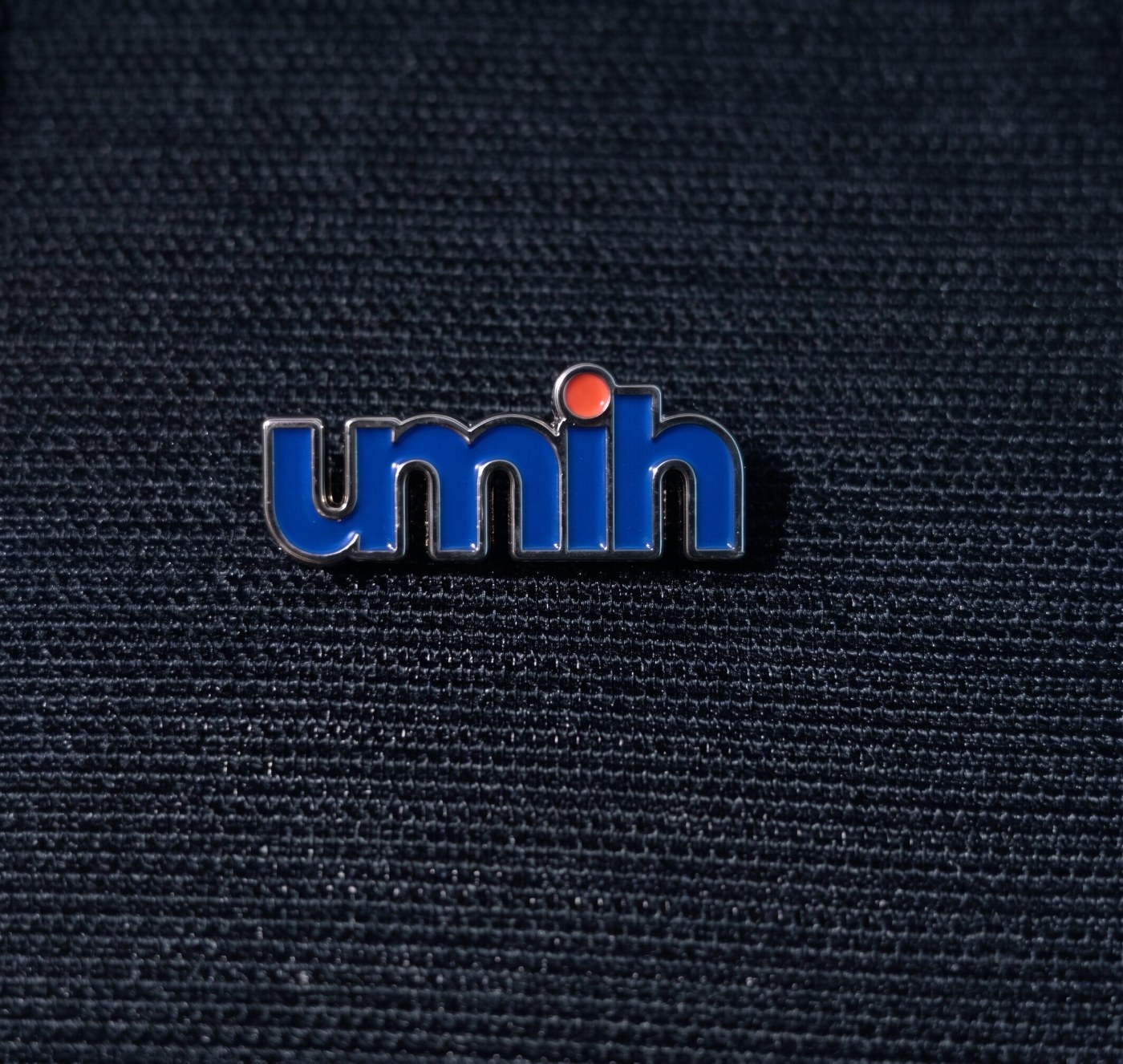 Pin’s UMIH Union des Métiers et des Industries de l’Hôtellerie, résine émaillée sur métal brillant fond grainé fin, réalisé par Promosapiens